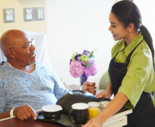 caregiver giving meal to a senior man